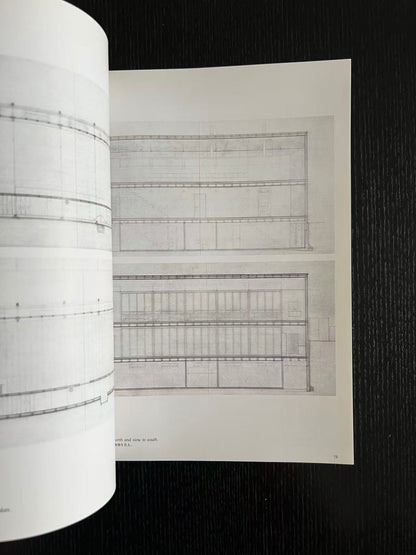 Roll of graph paper with a sheet of architectural drawings on a black background