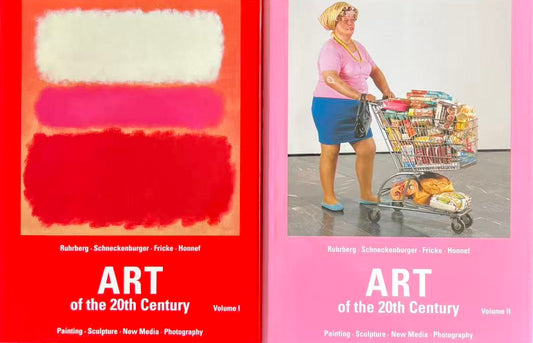 Two books on art of the 20th century on a black surface with a patterned fabric background.